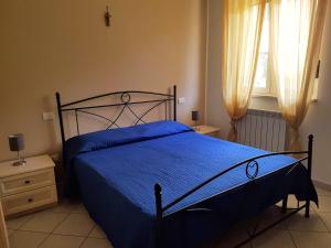 una camera con un letto blu e una finestra di CASAVACANZA - Marina a San Salvo