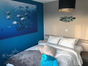um quarto com uma cama com um quadro na parede em Appartement The Lighthouse em De Haan