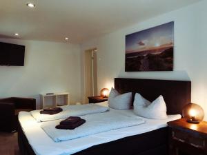 een slaapkamer met een bed met twee handdoeken erop bij Pension Die Schlafstube in Neuharlingersiel