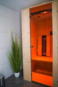 ラーデボイルにあるFerienwohnung Radebeul Gerlachの室内の植物を使ったオレンジ色のキャビネット