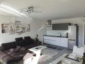 ein Wohnzimmer mit einem Sofa und einer Küche in der Unterkunft Apartment VAL in Koper
