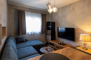 a living room with a blue couch and a television at Apartmán Trenčan in Považská Bystrica