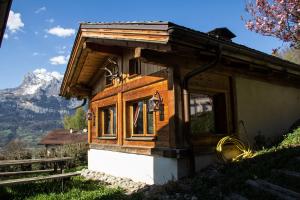 a small wooden house with a mountain in the background at Chalet cosy proche Tramway du Mont-Blanc et centre in Saint-Gervais-les-Bains