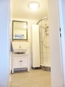 a bathroom with a sink and a shower and a mirror at Ferienwohnung Sonnenstrahl in Walsrode