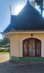 a small building with a black roof at Elo Apartman in Csokonyavisonta