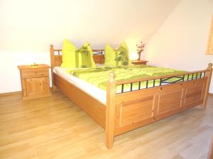 a bedroom with a large wooden bed with yellow pillows at Birkenstraße 6K in Zingst