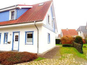 a white house with a red roof at Birkenstraße 6K in Zingst