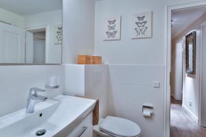 ein weißes Badezimmer mit Toilette und Waschbecken in der Unterkunft Pebbles in Westerland