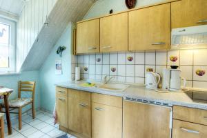 uma cozinha com armários de madeira e um lavatório em Schäfer, Renate FW 1 em Zingst