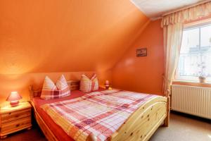 um quarto com uma cama com paredes cor de laranja e uma janela em Schäfer, Renate FW 1 em Zingst