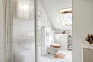 uma casa de banho branca com um chuveiro e um WC. em Schäfer, Renate FW 1 em Zingst
