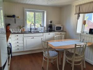 a kitchen with a table and chairs and a sink at Nära Smögenbryggan in Smögen