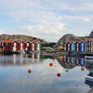 eine Reihe farbenfroher Häuser auf einem Wasserkörper in der Unterkunft Nära Smögenbryggan in Smögen