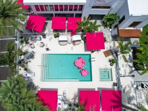 una vista aérea de una piscina con toques rosas en The Saint Hotel en St Pete Beach