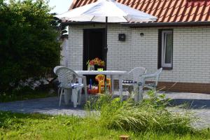 a table and chairs with an umbrella in front of a house at Feriendomizil "Anker" H 2 in Trent