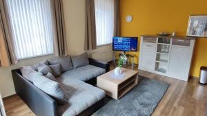 uma sala de estar com um sofá e uma televisão em Ferienwohnung Viaduktblick mit Balkon & MeineCardPLUS em Willingen