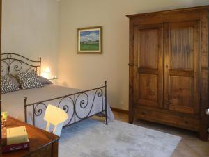 1 dormitorio con 1 cama y armario de madera en Profumi..., en Vinchio