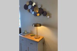 a lamp on a dresser next to a wall with seashells at Mayfield Apartment Luxury first floor 1 bedroom apartment in Great Eccleston