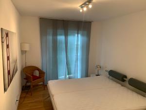 a small bedroom with a bed and a chair at Golfsuite Axel in Uttlau-Haarbach in Haarbach