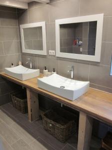 a bathroom with two sinks and two mirrors on a counter at Liebes-Lottchen in Krummhörn