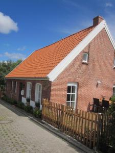 a red brick house with an orange roof at Liebes-Lottchen in Krummhörn