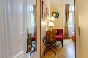 Zimmer mit einem Stuhl, einem Tisch und einem Zimmer in der Unterkunft Hotel Herzoghof in Baden
