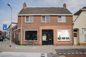 una casa de ladrillo con un perro en una ventana en Hippocampus aan Zee, en Katwijk aan Zee