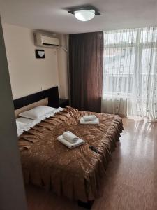 a bedroom with a bed with two towels on it at Pensiunea Eric in Iaşi