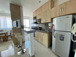 uma cozinha com um frigorífico branco e armários de madeira em Hermoso Apartamento con Piscina 1 Habitacion AT55 em Montería