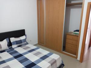 a bedroom with a blue and white bed and a dresser at Apartamento Novo, Brand New Apartament T1, Cidadela, Praia, Cabo Verde in Praia