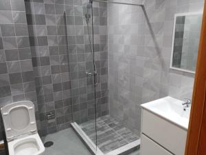 a bathroom with a shower with a toilet and a sink at Apartamento Novo, Brand New Apartament T1, Cidadela, Praia, Cabo Verde in Praia