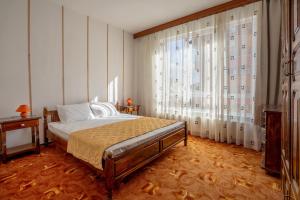 ein Schlafzimmer mit einem Bett und einem großen Fenster in der Unterkunft Къща за гости Арт Хаус - Юг/ Art House - South in Sandanski