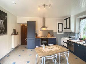 BurdigninGîte Vallée Verte的厨房配有蓝色橱柜和桌子及椅子 更多33张照片