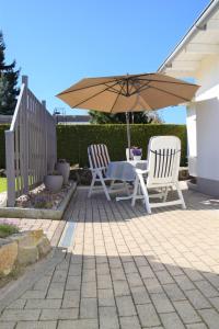 two chairs and an umbrella on a patio at Ferienwohnung Borken in Bad Salzungen