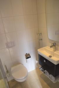 a white bathroom with a toilet and a sink at Ferienwohnung Borken in Bad Salzungen