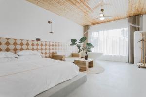 una camera da letto con un grande letto bianco e una vasca di 峨眉山一方民宿Mount Emei Little Place Guesthous a Monte Emei (Emeishan)