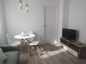uma sala de estar com uma mesa e uma televisão em Precioso apartamento en San Juan de Alicante em San Juan de Alicante