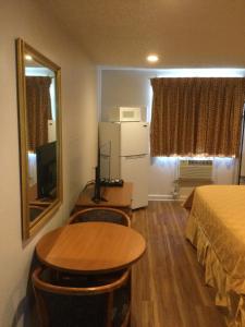 a small room with a table and a bed and a television at Americas Express Inn Rocky Mount in Rocky Mount