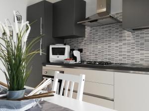 uma cozinha com um micro-ondas, uma mesa e cadeiras em AliceA apartment in Siracusa em Siracusa