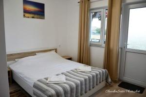 a bedroom with a bed with two towels on it at Pensiunea La Codru in Jurilovca