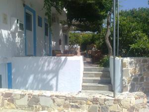 a white house with stairs and a wall at Dionysia Studios in Kefalos
