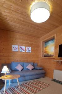 a living room with a blue couch in a wooden room at Urlaub mit Aussicht in Pfarrwerfen