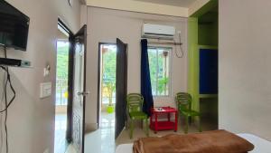 a bedroom with a bed and two green chairs at Green Earth Resort in Lataguri