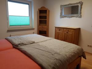 a bedroom with a bed and a window and a dresser at Ferienwohnung Mohnblume in Rosdorf