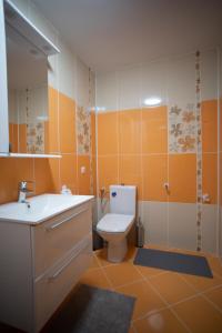 a bathroom with a toilet and a sink at Aquarium Apartment in Buzău