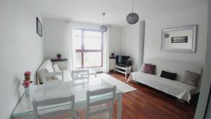 una sala de estar blanca con mesa y sillas en Apartament Bello - free parking, en Gdansk