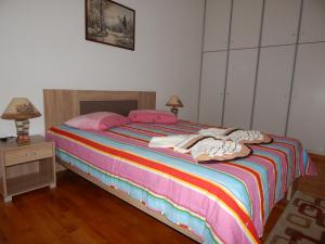 トリポリスにあるCozy apartment for 2-5 people-Center Tripoli 1のピンクとカラフルなシーツが敷かれた大きなベッドのある寝室 +9枚の写真