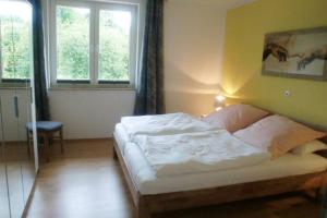 ein Schlafzimmer mit einem Bett in einem Zimmer mit Fenstern in der Unterkunft Oase im Dresdner Westen in Dresden