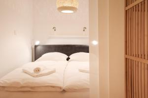 um quarto com uma cama com lençóis brancos e toalhas em Ferienwohnung Sonnenglück mit großzügigem Südbalkon em Lenzkirch