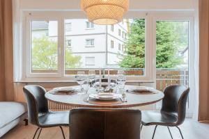 comedor con mesa, sillas y ventanas en Ferienwohnung Sonnenglück mit großzügigem Südbalkon, en Lenzkirch